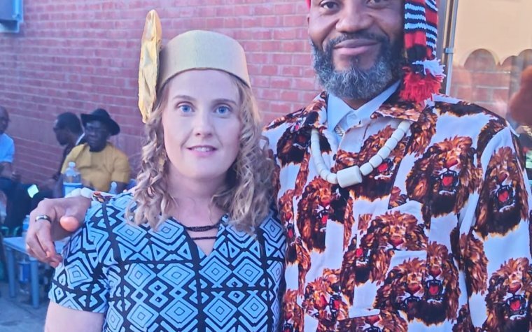 Igbo Union Northamptonshire - Two members at a gathering, one in Igbo dress with a red cap