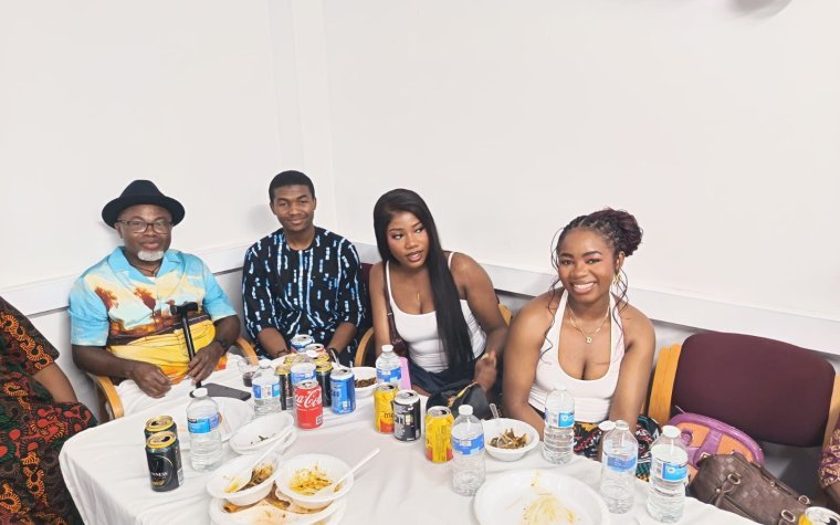 Igbo Union Northamptonshire - Four young members seated behind a table of food and drinks at a gathering