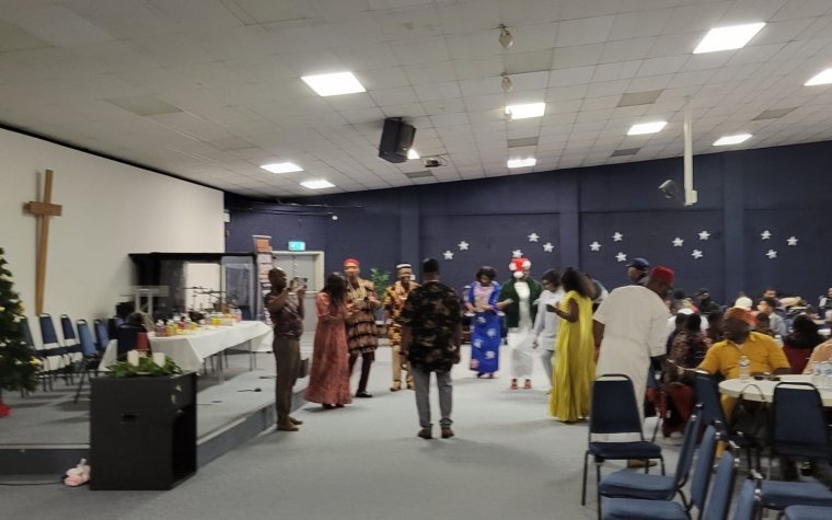 Igbo Union Northamptonshire - Members gathering and talking together in a church hall before an event
