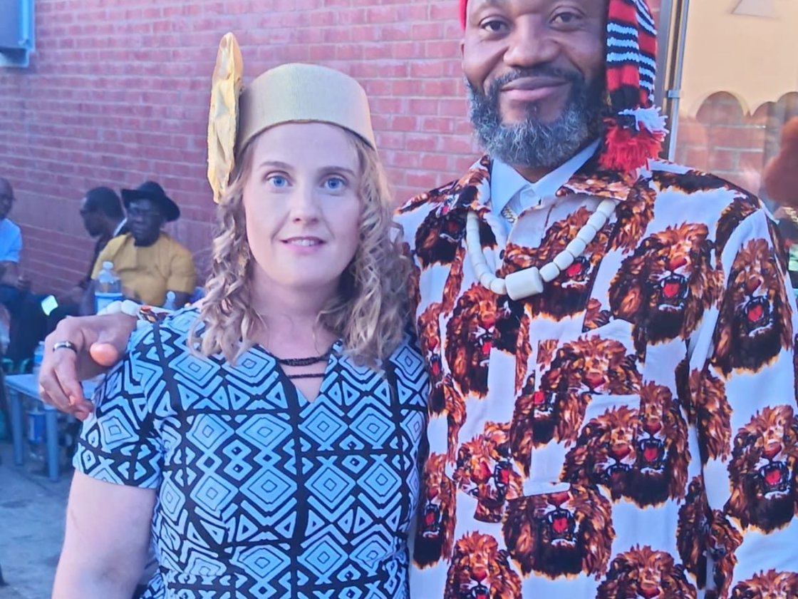 Igbo Union Northamptonshire - Two members at a gathering, one in Igbo dress with a red cap